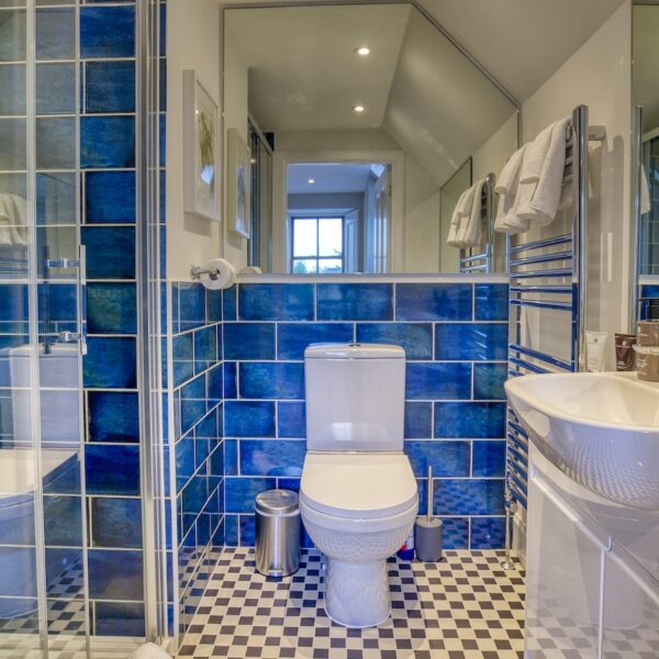 Ensuite showerroom with bright blue tiling in The Meadows, Dornoch