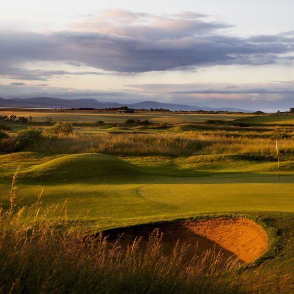 1st hole of Tain golf course in golden light, looking north towards Sutherland