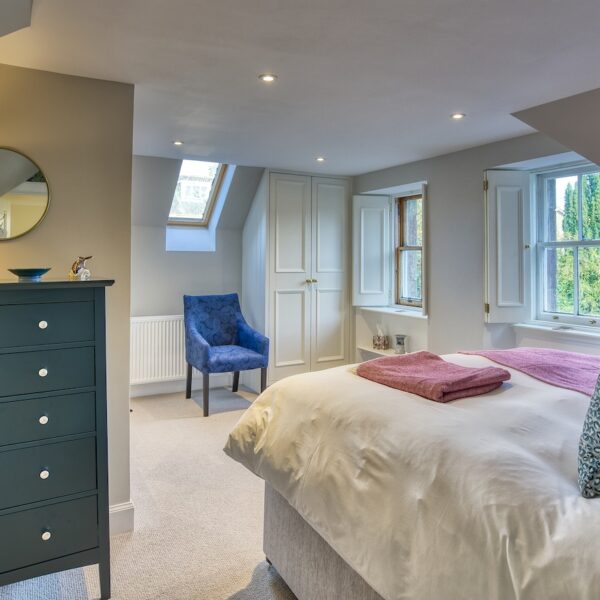 Double bedroom with white walls and navy blue chest of drawers, The Meadows, Dornoch