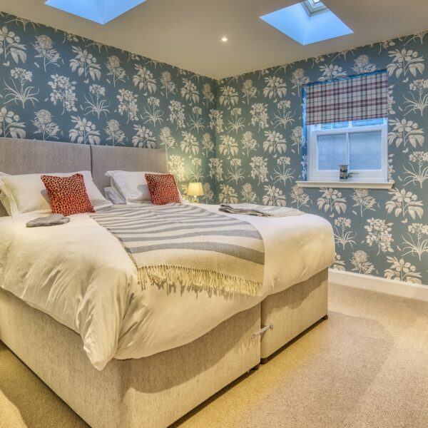 Double bedroom with green wallpaper and red occasional chair, The Meadows, Dornoch