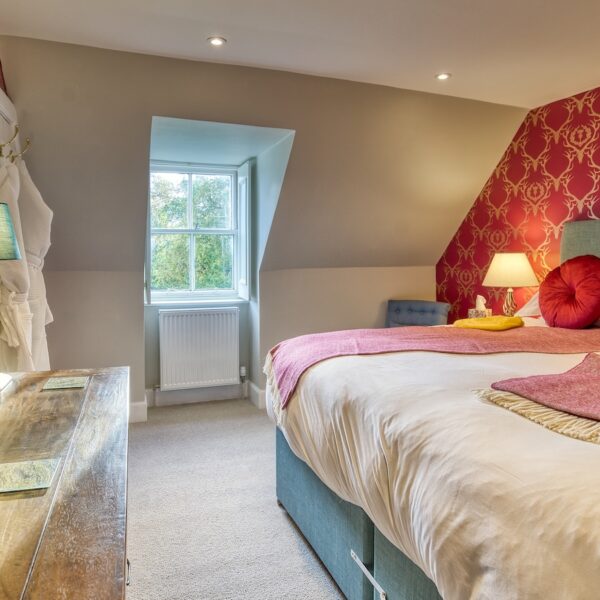 Double bedroom with red stags head pattern wallpaper feature wall, The Meadows, Dornoch