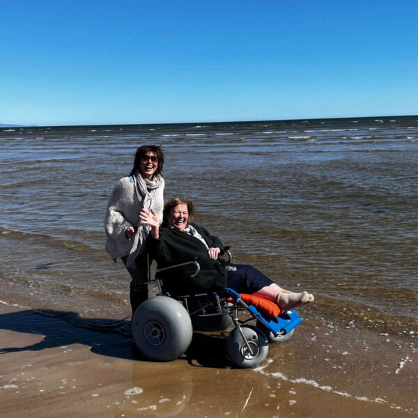 Dornoch beach wheelchair charity ladies in water at dornoch beach