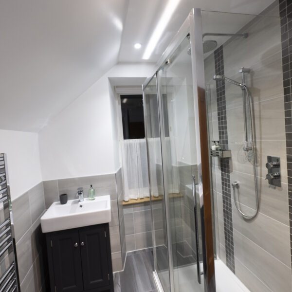 Shower room with grey accent tiling and white walls in 2 Quail, Dornoch