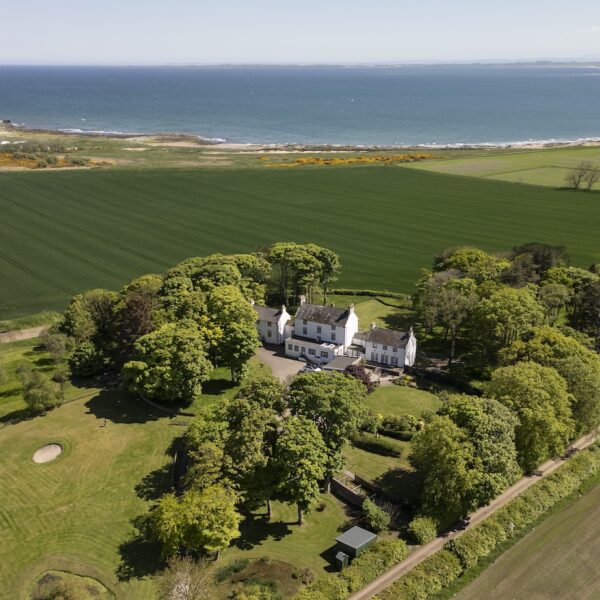 Aerial view of Embo House, looking across surrounding field and out over north sea