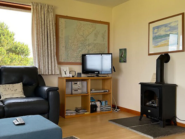 Living room with electric stove in 25 Skelbo Muir, Dornoch