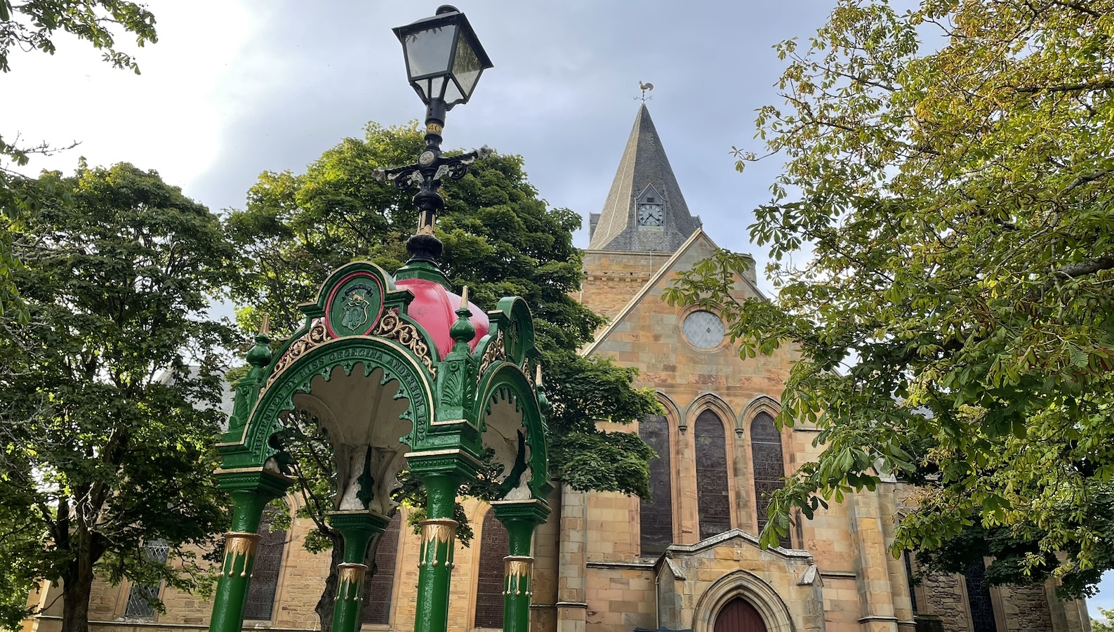 Image of fountain and Cathedral in Dornoch, Scotland on sunny day