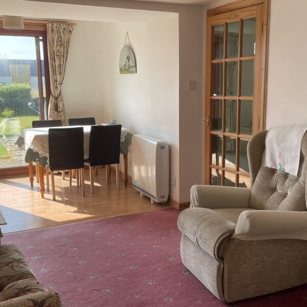 sitting area and dining table next to patio doors, Achlean Holiday cottage, Dornoch