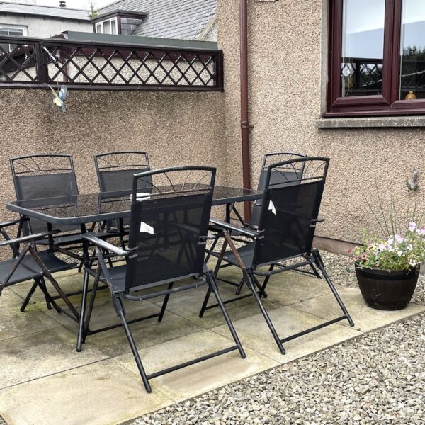 Outside sitting area with black garden table and chairs at Oystercatcher, Gate Street, Embo