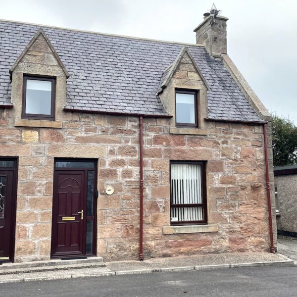 Exterior of Oystercatcher, Gate Street, Embo with dark brown door and window frames set in sandstone wall