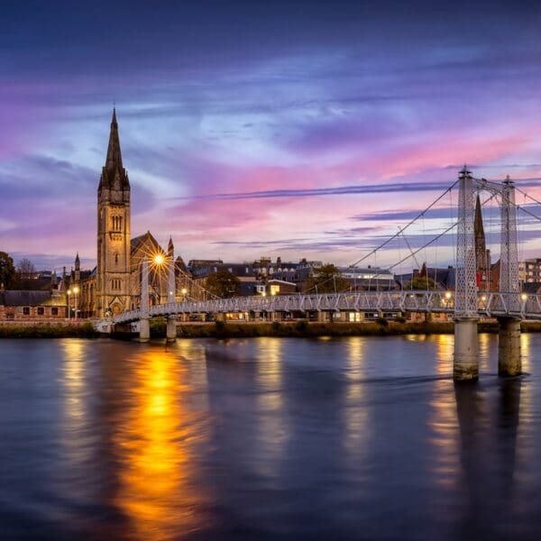 Panoramic view of the cityscape of Inverness, Scotland, during evening time with Greig Street Bridge, River Ness and the old town