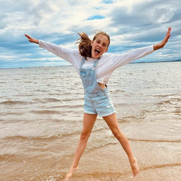 Girl jumping in water on Dornoch Beach