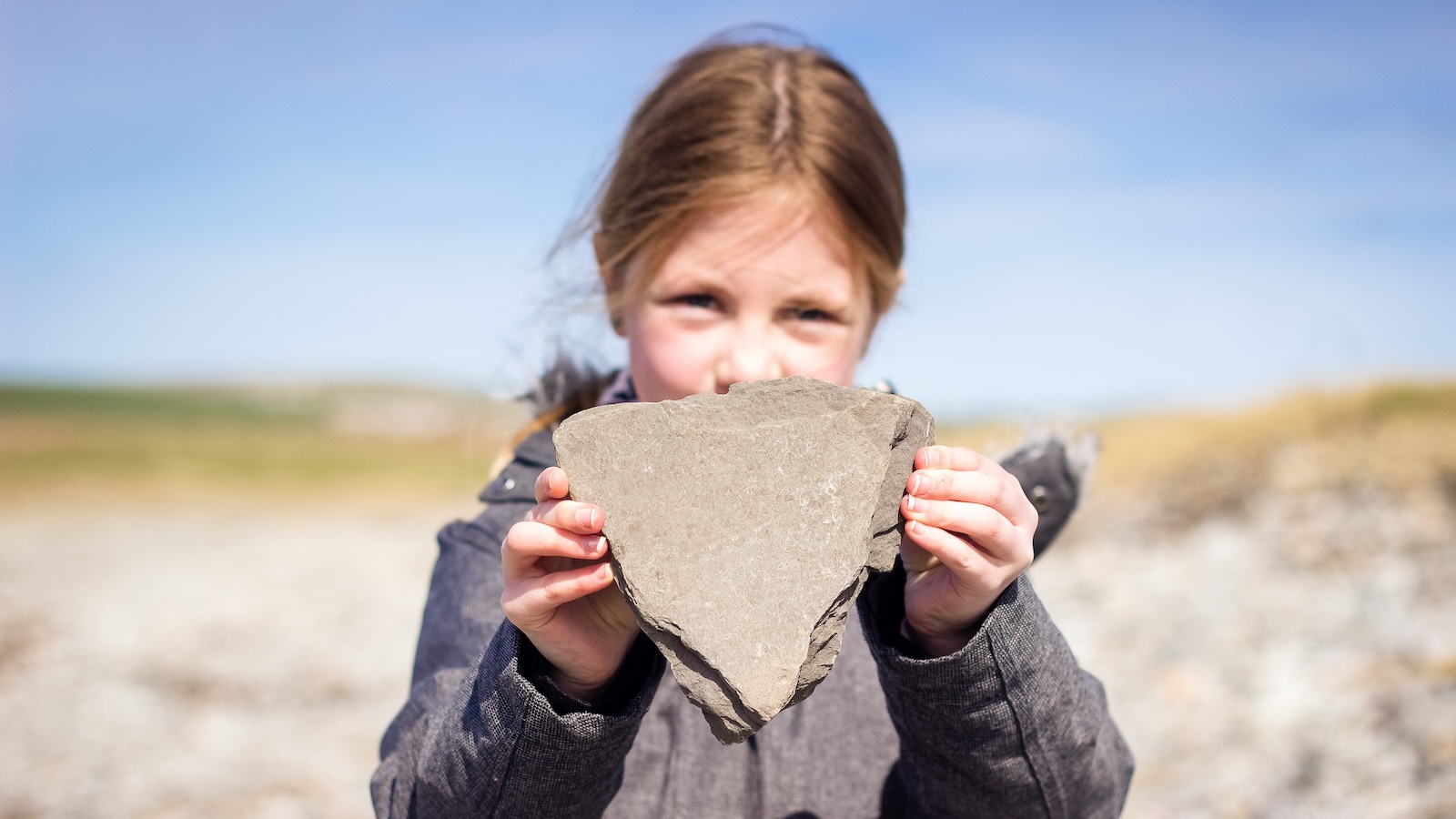 Girl holding triangle shaped stone, Dornoch beach